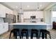 Bright kitchen with white cabinets, stainless steel appliances, and island seating at 17301 Tribute Row, Noblesville, IN 46060