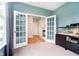 Bright office with French doors, neutral carpet and an aquarium adding a touch of serenity to the room at 17301 Tribute Row, Noblesville, IN 46060
