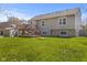 Back exterior view of home, featuring a large backyard, deck, and mature trees at 1736 Sandoval Ct, Indianapolis, IN 46214