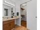 Bathroom with vanity, mirror, modern lighting, and open closet with clothing racks at 1736 Sandoval Ct, Indianapolis, IN 46214