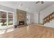 Open-concept living room with stone fireplace, wood floors, and easy access to the home's staircase at 1736 Sandoval Ct, Indianapolis, IN 46214