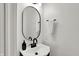 Modern bathroom featuring an oval mirror, sleek black faucet and dispenser, and a fresh white towel at 1818 Orleans St, Indianapolis, IN 46203