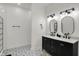 Modern bathroom featuring double vanity, decorative mirrors, and tile flooring with an adjacent glass enclosed shower at 1818 Orleans St, Indianapolis, IN 46203