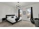 Bright bedroom featuring a modern chandelier, dark curtains and sleek black furniture and accents at 1818 Orleans St, Indianapolis, IN 46203