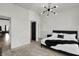Bright bedroom featuring a modern chandelier, and sleek black door and furniture contrasting nicely with the white walls at 1818 Orleans St, Indianapolis, IN 46203