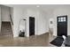Spacious foyer with a staircase, large mirror, black accent doors, and wood-look vinyl floors at 1818 Orleans St, Indianapolis, IN 46203