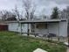 Backyard view of home featuring a covered patio, white siding and shuttered windows at 1830 S Chester Ave, Indianapolis, IN 46203