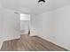 This bedroom features wood-look flooring, white walls, and an open closet with a light fixture at 1842 W Kessler Blvd N Dr, Indianapolis, IN 46228