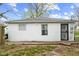 Rear exterior of home with metal security door and classic grey roof, complemented by an open grassy area at 1842 W Kessler Blvd N Dr, Indianapolis, IN 46228