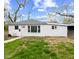 Quaint single-story home featuring a well-lit exterior, a gray roof and a manicured lawn at 1842 W Kessler Blvd N Dr, Indianapolis, IN 46228