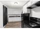 Bright kitchen with well-maintained white cabinets, black appliances, and durable wood-style flooring at 1842 W Kessler Blvd N Dr, Indianapolis, IN 46228