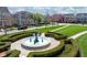 Close up of a beautiful water fountain in the neighborhood, surrounded by landscaping and walkways with trees, plants, and flowers at 2197 Duke Of York St, Carmel, IN 46032