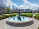Picturesque water fountain framed by manicured hedges and blossoming trees against a backdrop of stately homes at 2197 Duke Of York St, Carmel, IN 46032