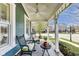 Inviting front porch with comfortable seating, decorative plants, and a ceiling fan for a relaxing outdoor experience at 2197 Duke Of York St, Carmel, IN 46032
