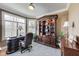 Cozy office space featuring a built-in bookcase, a bay window with plantation shutters, and a desk at 2197 Duke Of York St, Carmel, IN 46032