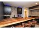 Basement bar with a wooden countertop, leather stools, black cabinets, and stone backsplash at 2280 Meadow Crk, Avon, IN 46123