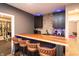 Basement bar with a wooden countertop, leather stools, stone backsplash, and cabinets with lighting at 2280 Meadow Crk, Avon, IN 46123