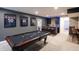 Finished basement with a pool table, bar with seating, and framed sports jerseys on the wall at 2280 Meadow Crk, Avon, IN 46123