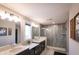 Bathroom with double vanity sinks, quartz countertops, a shower with gray-scale tiling, and natural light at 2280 Meadow Crk, Avon, IN 46123