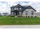 Beautiful two-story home with stone and gray siding, a well-manicured lawn, and professional landscaping at 2280 Meadow Crk, Avon, IN 46123