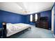 This bedroom features blue walls, a ceiling fan, and a dresser with a TV at 2372 S 300 E, Anderson, IN 46017