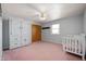 Bedroom featuring pink carpet, wooden closet and a white ceiling fan and light fixture at 2372 S 300 E, Anderson, IN 46017