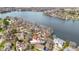 A white home with a red roof is nestled among trees on the shores of a large lake at 2469 Cape Henry Ct, Cicero, IN 46034