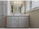 Bathroom features double sink vanity with white cabinets, drawers, and unique octagonal mirrors and lighting at 2469 Cape Henry Ct, Cicero, IN 46034