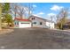 A charming white house with a red roof and driveway, complemented by natural landscaping and mature trees at 2469 Cape Henry Ct, Cicero, IN 46034