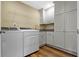 Well-organized laundry room with cabinets, counter space, utility sink, and modern washer and dryer at 2469 Cape Henry Ct, Cicero, IN 46034