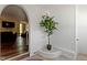Arched doorway leads into an open-concept living room featuring brick walls and hardwood floors at 2469 Cape Henry Ct, Cicero, IN 46034