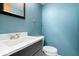 Stylish half-bathroom with modern vanity and a sleek toilet against blue walls at 315 Heritage Ct, Fishers, IN 46038