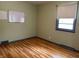 A simple bedroom shows hardwood floors and a window at 3315 Hillcrest Dr, Columbus, IN 47203