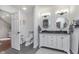 Modern bathroom with double vanity, decorative wallpaper, and a connected toilet room at 333 S Fourth St, Zionsville, IN 46077