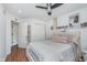 Bedroom featuring a ceiling fan, wood floors, closet, and adjacent bathroom at 333 S Fourth St, Zionsville, IN 46077