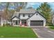 Charming two-story home with a landscaped front yard and an attached two-car garage, painted in white with black accents at 333 S Fourth St, Zionsville, IN 46077