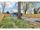A backyard view featuring a blue garage, lawn, and wood fence at 3433 Brouse Ave, Indianapolis, IN 46218