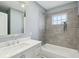 Modern bathroom featuring large mirror, updated tiling, and a tub and shower combination at 3433 Brouse Ave, Indianapolis, IN 46218