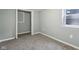 A carpeted bedroom with a small window and an open closet at 3433 Brouse Ave, Indianapolis, IN 46218