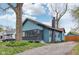 Charming blue home featuring a brick chimney, well-manicured lawn, and a paved driveway and mature trees at 3433 Brouse Ave, Indianapolis, IN 46218