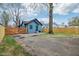 View of blue house with large tree and gated driveway, nestled among other homes at 3433 Brouse Ave, Indianapolis, IN 46218