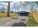 Exterior shot of detached garage with large drive and wooden privacy fence on sunny day at 3433 Brouse Ave, Indianapolis, IN 46218