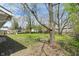 A sprawling green backyard, framed by mature trees, provides a serene outdoor space at 3703 Dubarry Rd, Indianapolis, IN 46226