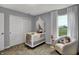 Cozy Bedroom showcases a white crib, comfortable chair, and a serene view from the window at 4105 Ashton View Ln, Indianapolis, IN 46268