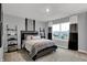 Bright bedroom featuring gray walls, large windows, stylish striped bedding and matching dark wood furniture at 4105 Ashton View Ln, Indianapolis, IN 46268