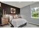 Stylish bedroom featuring a wooden bed frame, decorative pillows, and a modern accent wall for a contemporary design at 4105 Ashton View Ln, Indianapolis, IN 46268