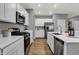 Bright kitchen features white cabinetry, stainless steel appliances, and a sleek, modern design with light gray walls at 4105 Ashton View Ln, Indianapolis, IN 46268