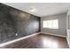Inviting bedroom featuring a dark gray accent wall, hardwood flooring, and a bright window at 4505 Phoenix Dr, Indianapolis, IN 46241