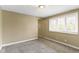 A bedroom featuring tan colored walls and carpet, and a window with blinds at 4505 Phoenix Dr, Indianapolis, IN 46241
