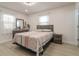 Bright bedroom with white floors, a queen-sized bed, and a dresser with mirror at 5510 Chelsea Rd, Indianapolis, IN 46241